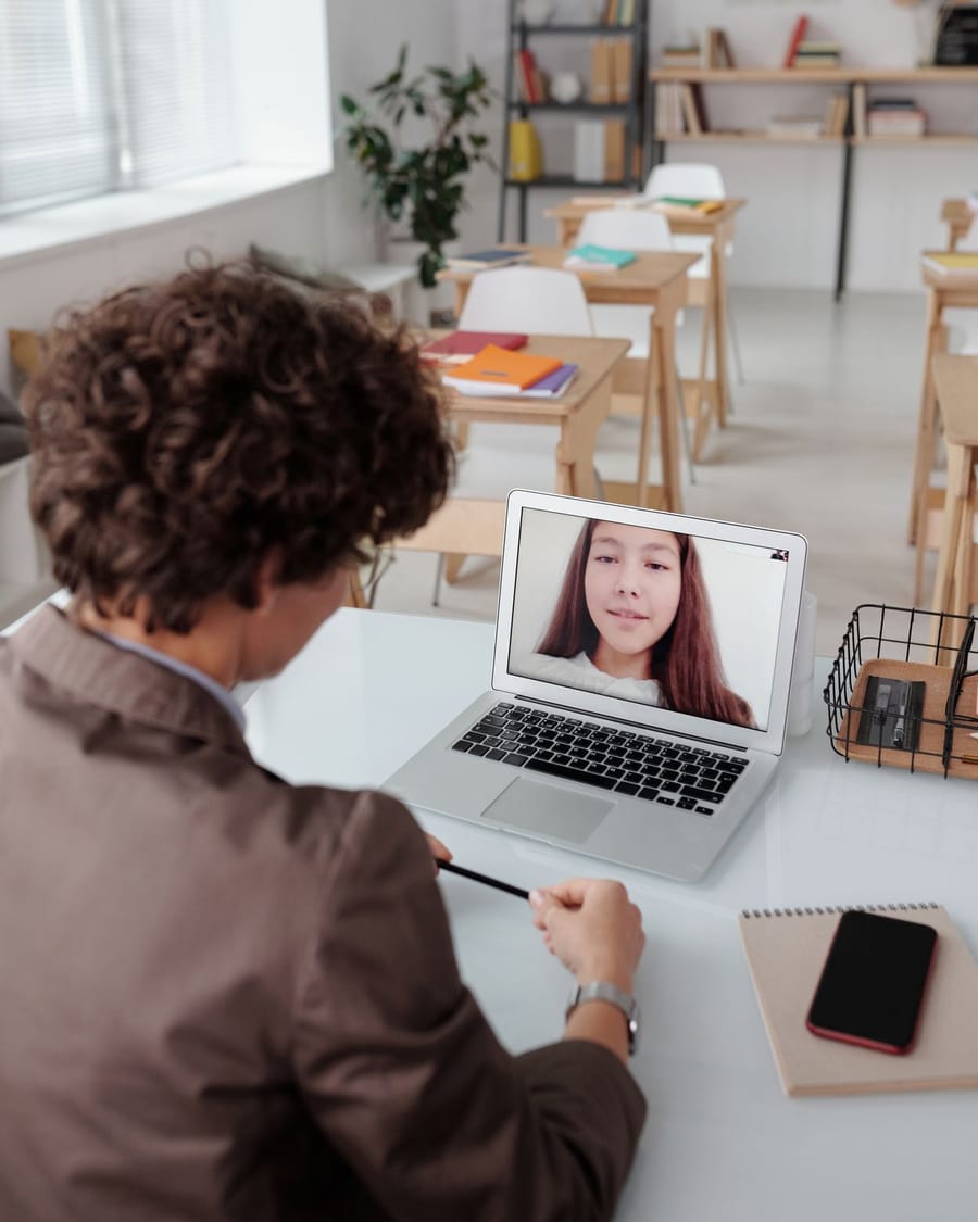 Profesora y estudiante participan en una clase por videollamada.